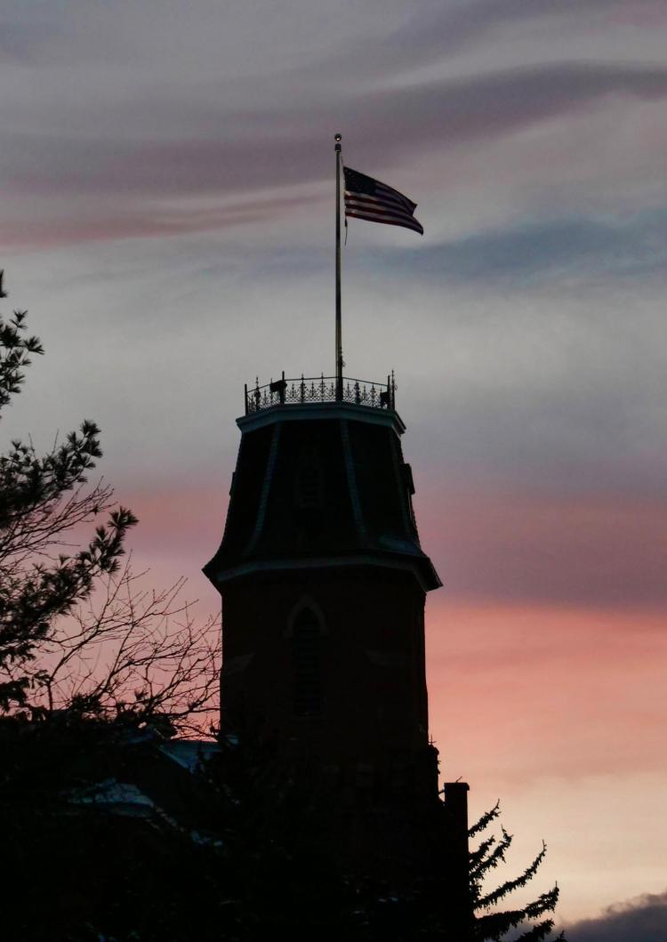 Silhouette of Old Main with sunset in background