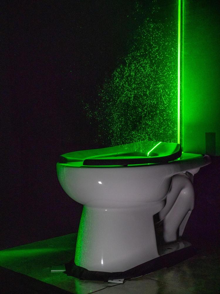 A powerful green laser helps visualize the aerosol plumes from a toilet