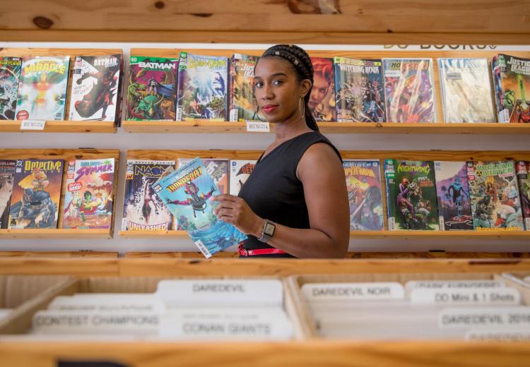 Stephanie Toliver in a comic book store reading an issue of "Ironheart"