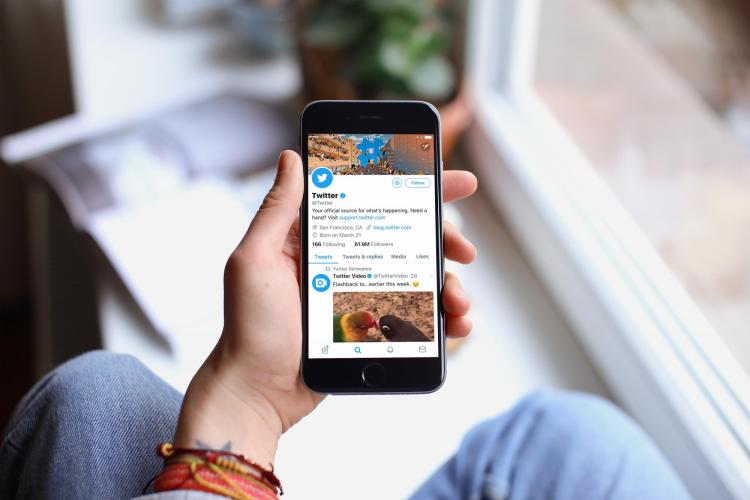 An image of a phone with a Twitter conversation on the screen