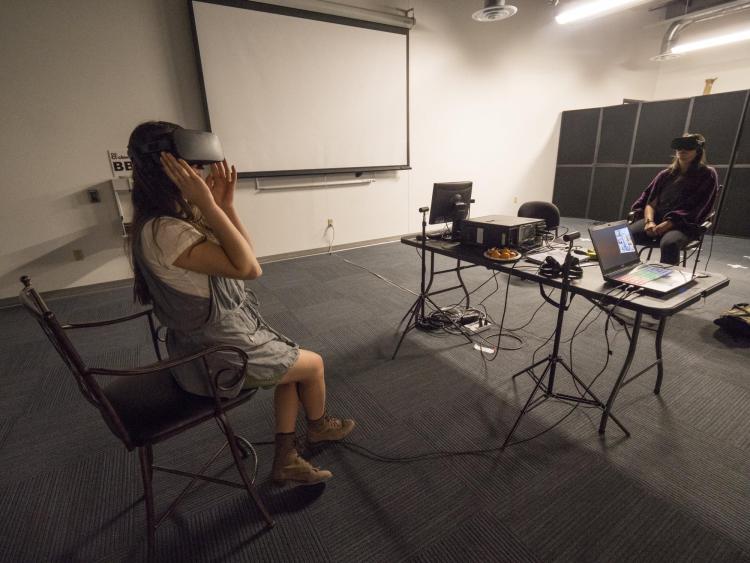 Visitors participate in an interactive digital exhibit at the open studios event. Photo by Glenn Asakawa.