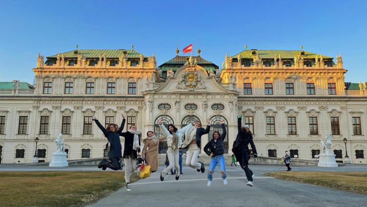 Group of students jumping in front of Belvedere Palace in Vienna, Austria
