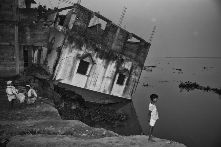 A house in India tipping precariously into the Ganges River