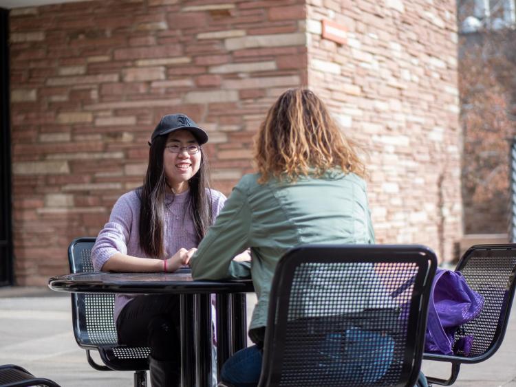 Zhen Qu talks with another student on campus