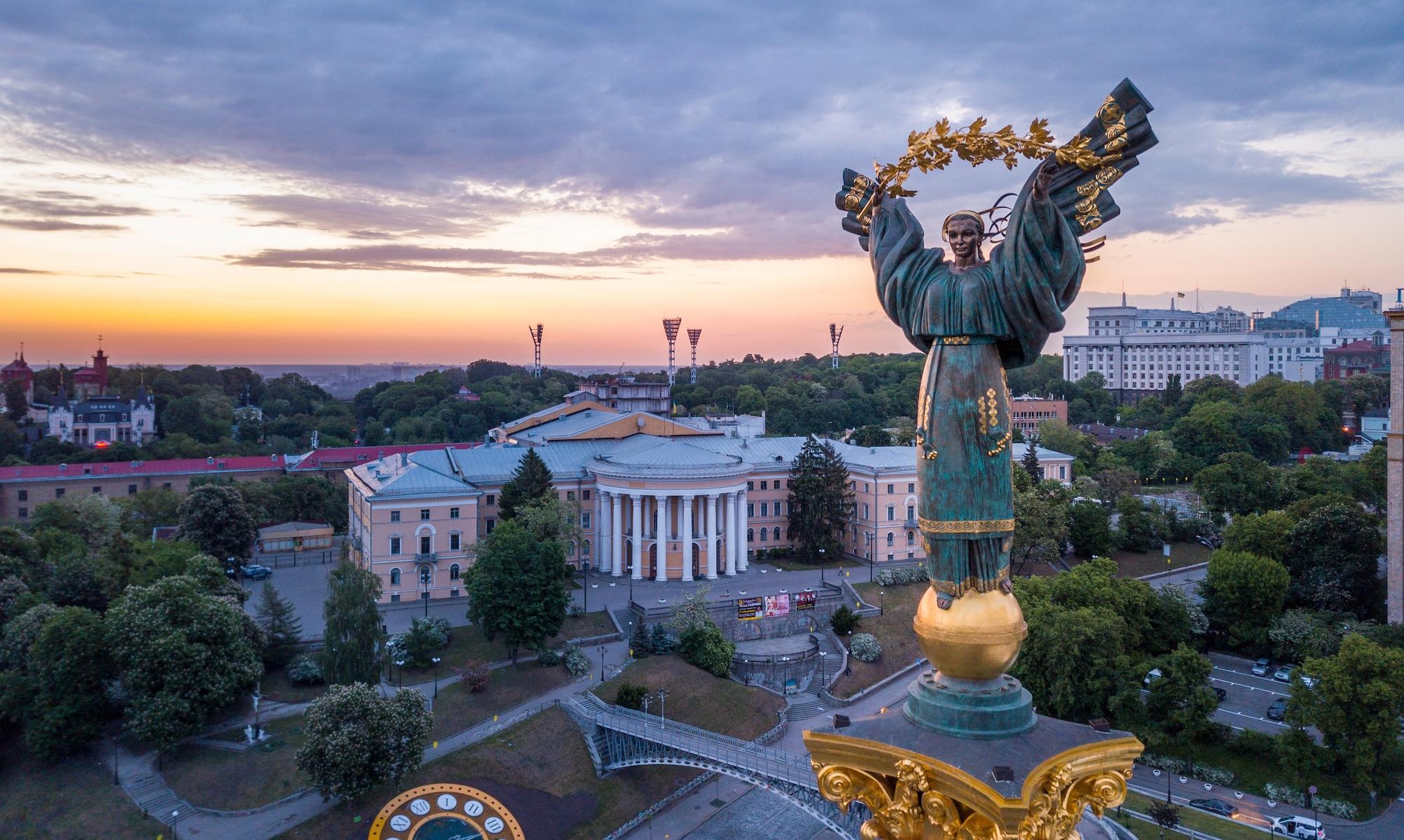 Statue of a winged angel with buildings in the background