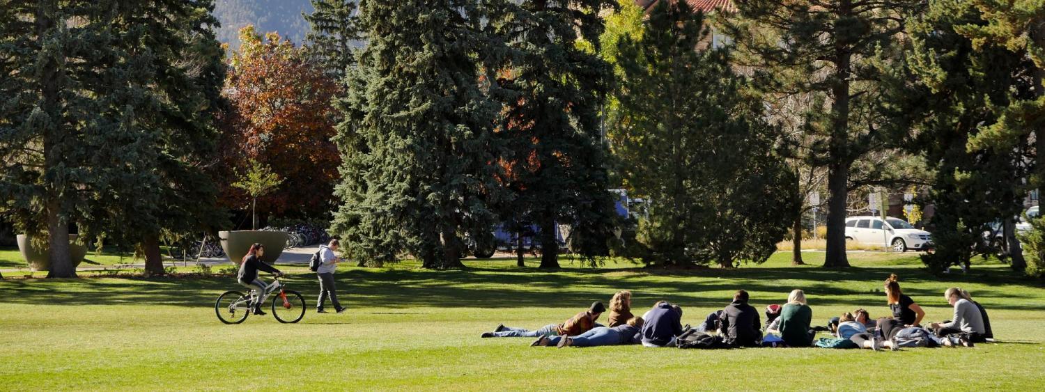 A class takes place outdoors on a grassy lawn.