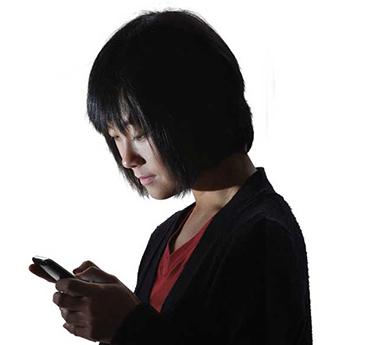 A woman looks at a message on her phone