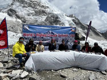 Joanna Lambert, Joel Berger, film and sound crew and Nepalese Mountaineering Association members sit at a table