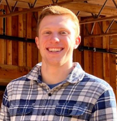 Man wearing white and blue plaid shirt poses for portrait