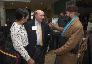 Chancellor Philip DiStefano greets professors Violeta Chapin (left) and Reiland Rabaka (right).