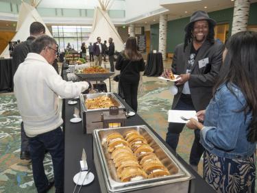 Attendees fill their plates with tacos and other catered food