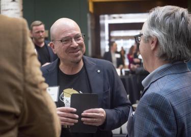 Professor John Michael-Rivera visits with Graduate School Dean Scott Adler.