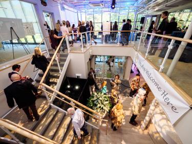 Guests mingle as a pattern of gold light filters through the atrium windows.