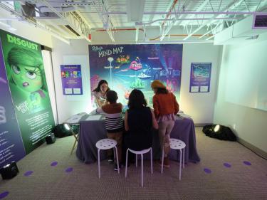 Christie Hubly helps a family with an art project in the InsideU Pixar room