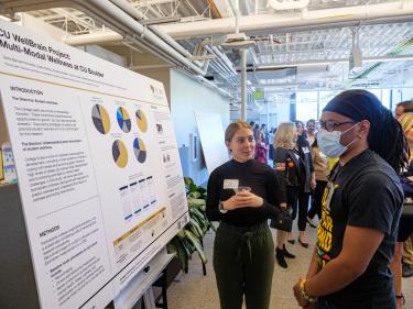 Guests look over research boards at the grand opening event.