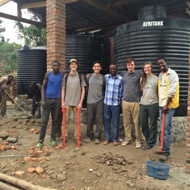 Curtis Gile and team in front of water catchment system