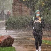 A student walking through the snow on the CU Boulder campus