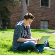 A student uses a laptop to study outside