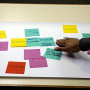 Campus community member adds sticky note to board during Diversity and Inclusion Summit