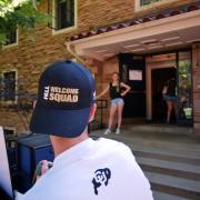 Man wearing black Fall Welcome Squad hat