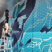 Artist Kendall Rose Kippley paints a mural in Boulder showing Arctic sea ice loss over time, based on NSIDC data. (Photo by Seamus McAfee, NSIDC)