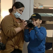 Lourdes Camarillo shows her camera to a curious child.