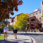 Campus community members walking on campus with fall foliage