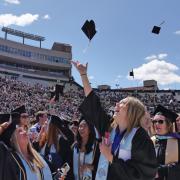 Graduates throw caps into the air. (CU Boulder)