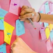 person writing on sticky notes