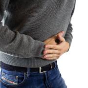 Man clutches stomach in pain