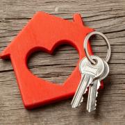 Stock image of keys on a keychain shaped like a house with a heart inside of it