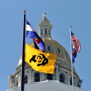 CU, State of Colorado and U.S. flags fly at Colorado state capitol  