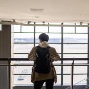 Person looks out window at airport