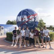 CU Boulder students in front of NASA sign at the Kennedy Space Center