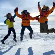 Researchers in Antarctica jumping in the air together