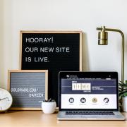 Photo of laptop with new Career Services website, sign that says "Hooray! Our new site is live."