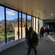 Campus community members walking past a window inside the CASE building