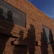 The shadows of visitors seen on the wall of the Columbine Memorial