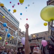 Students release biodegradable balloons as part of a course