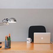 Empty chair at desk with laptop and coffee mug