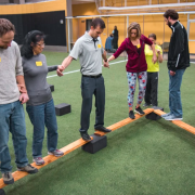 A group participates in an indoor challenge experience.