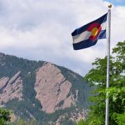 The majestic Flatirons provides a backdrop to the Colorado State Flag at the University of Colorado Boulder. (Photo by Casey A. Cass/University of Colorado)