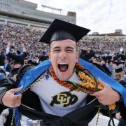 Graduate pulls a Superman, exposing a CU Buffs shirt under his robe