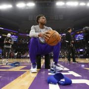 Basketball player sits on the court 