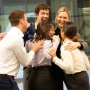 a group of students standing in a circle hugging