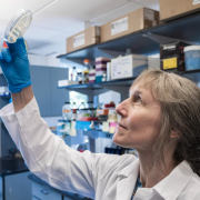 Professor Corrie Detweiler holding up a lab sample to the light