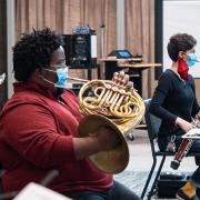 students wearing masks while playing brass and wind instruments 