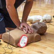 Person practicing CPR on a dummy