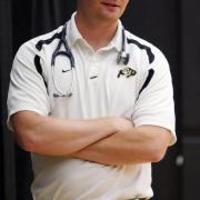 An unidentified man with arms crossed sports Buff gear and a stethoscope.