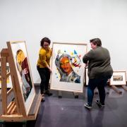 Students move artwork at the CU Art Museum's new exhibition, Persuasive Prints. 
